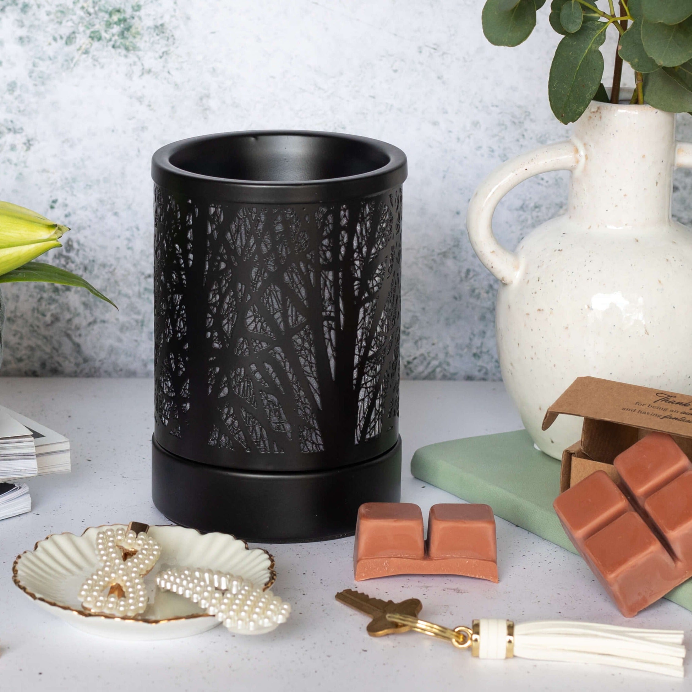 Black Forest Wax Warmer Styled in a Home Setting Black forest-pattern electric wax warmer styled beside wax melts and home accessories
